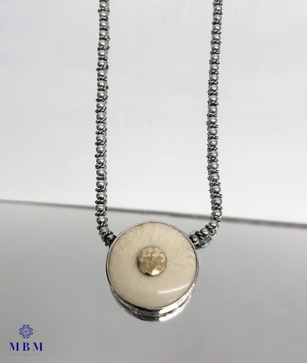 Silver and gold necklace with vegetable ivory medal